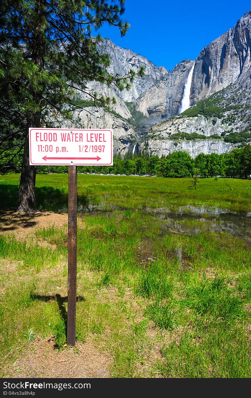 Landscape with Flood Water Level sign on the front and mountains and waterfall on the back. Landscape with Flood Water Level sign on the front and mountains and waterfall on the back.