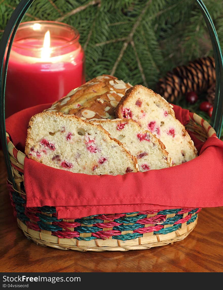 Basket of cranberry sweet bread with a burning candle in background. Basket of cranberry sweet bread with a burning candle in background