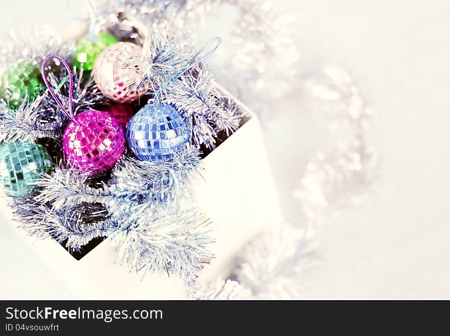 Box with Christmas ornaments on white background