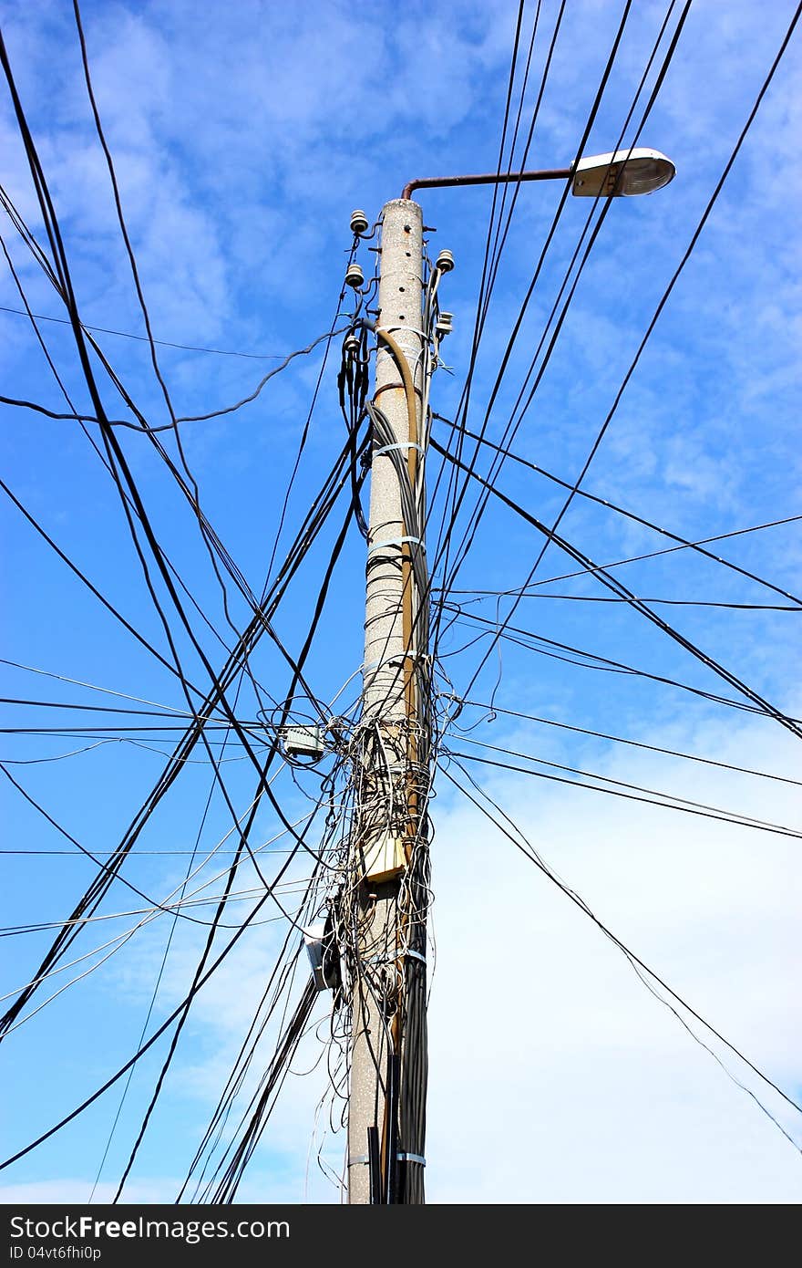 Electric pole with many wires and a lamp