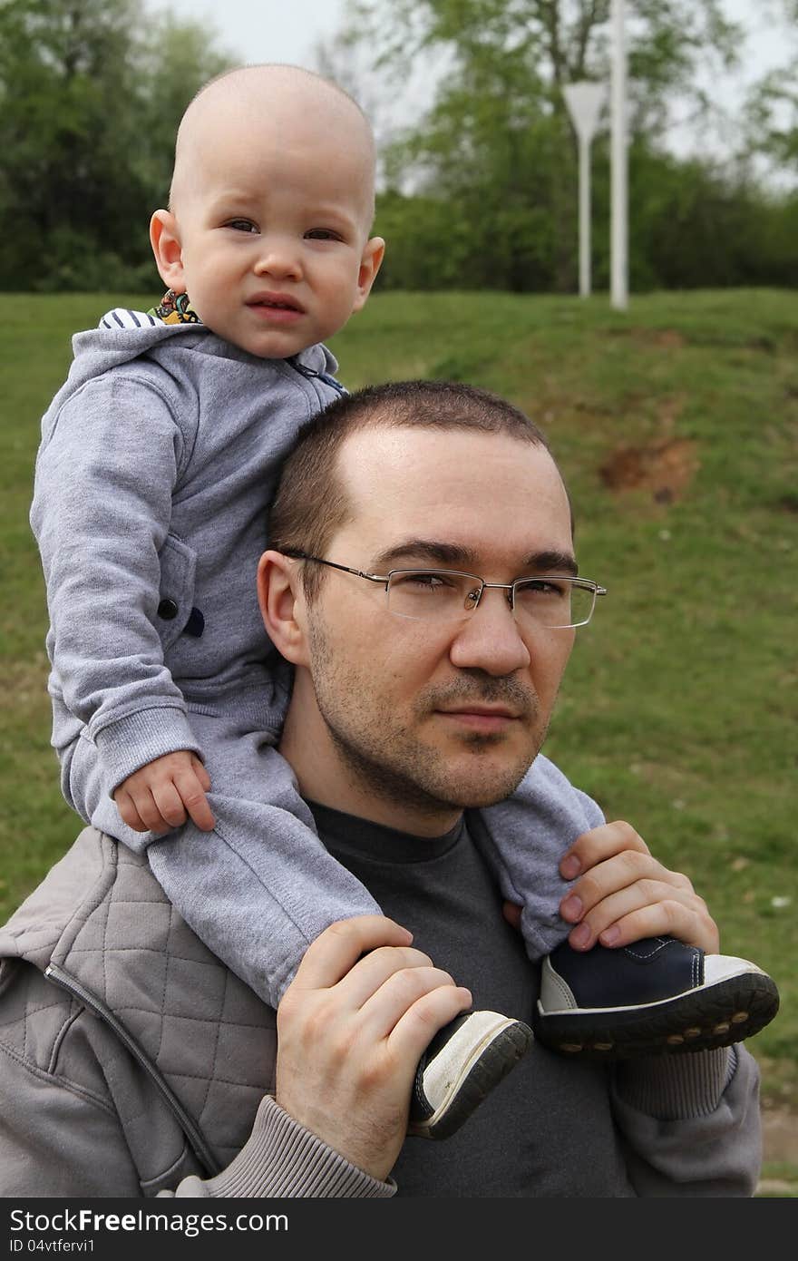 Father and son on a walk in the park.baby sitting on the shoulders of a man