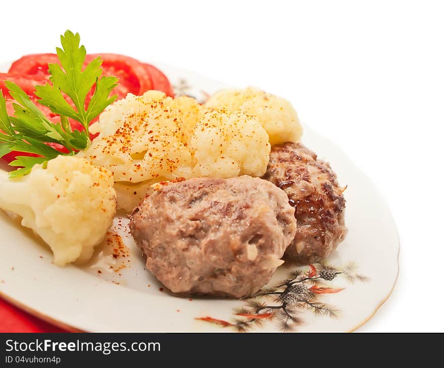 Fried meatballs with cauliflower and tomato on a nice plate