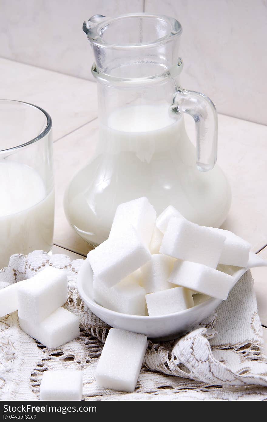 Jug and glass with milk and sugars