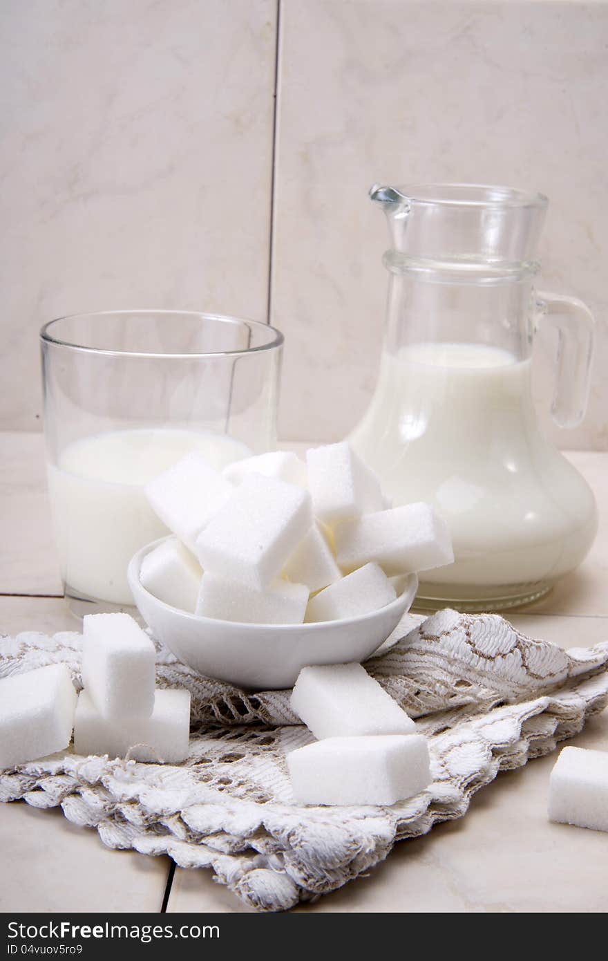 Jug and glass with milk and sugars