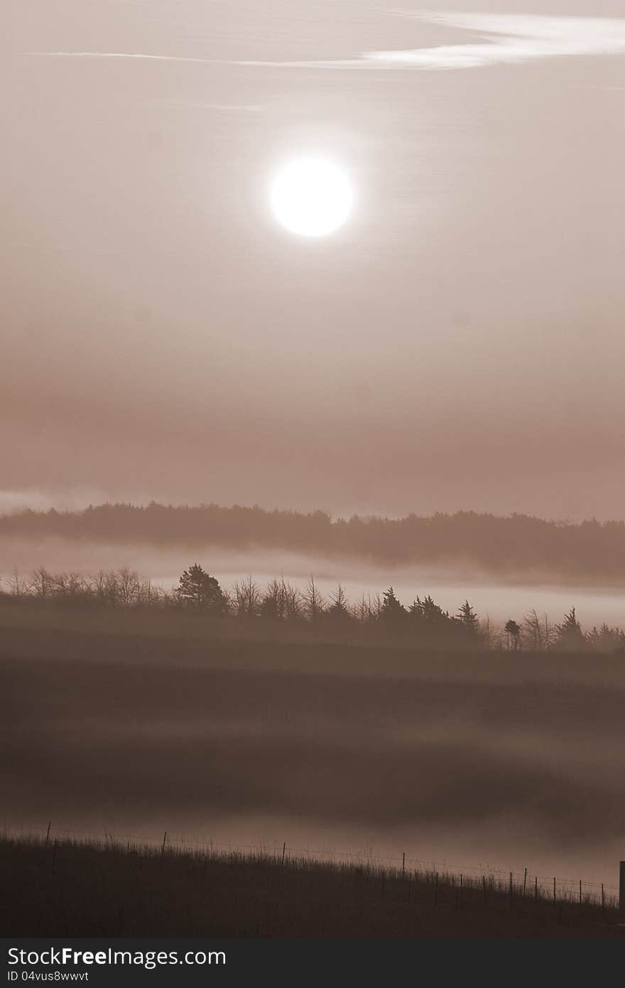 The sun rises on a foggy morning in the Flint Hills of Kansas. The sun rises on a foggy morning in the Flint Hills of Kansas