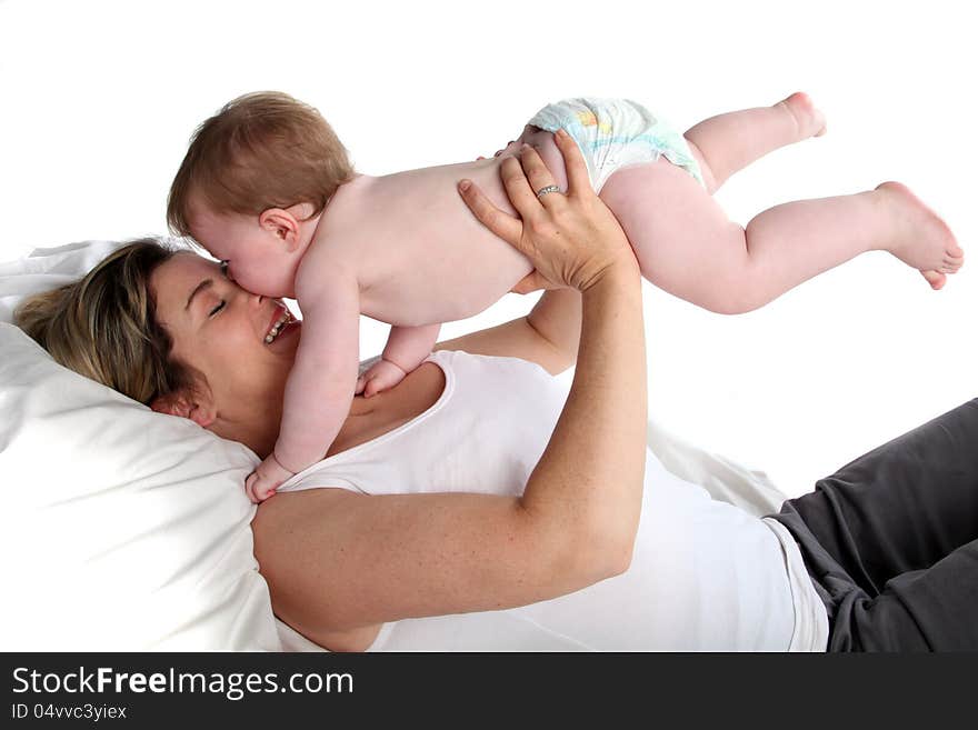 Content mother playing with her baby girl.  Baby kissing her mother on the nose. Content mother playing with her baby girl.  Baby kissing her mother on the nose.