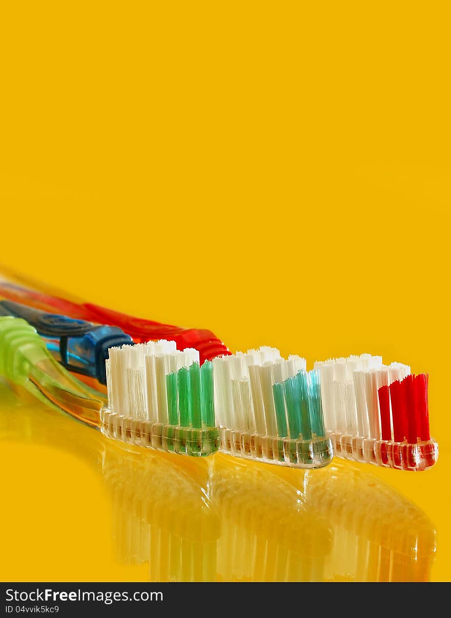 Colorful tooth brush set on yellow counter top. Colorful tooth brush set on yellow counter top