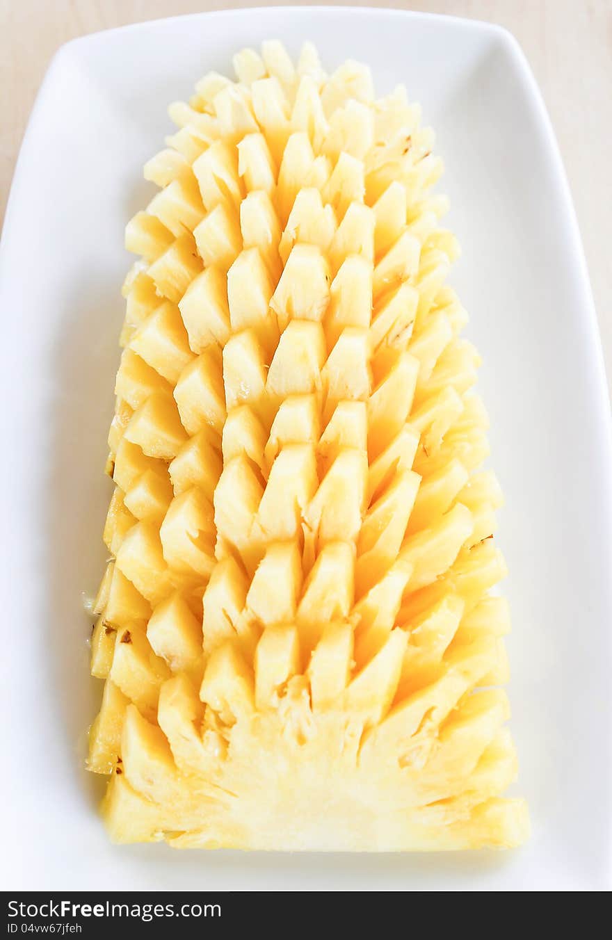 Pineapple sliced on white plate