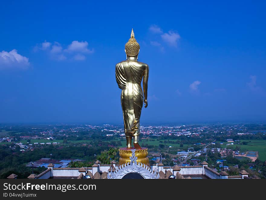 Black golden buddha statue against blue sky in thai temple