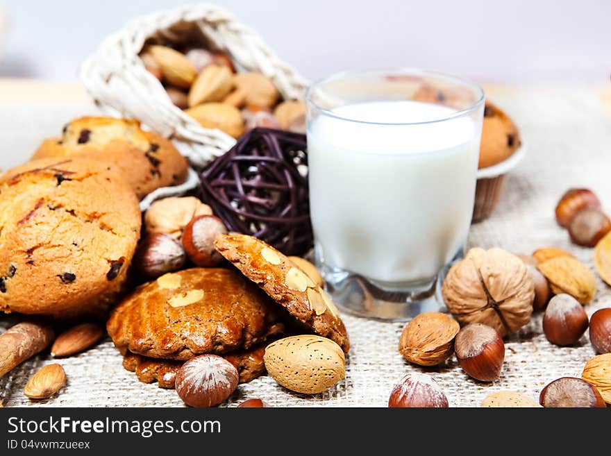 Cookies, nuts, muffins and glass with milk