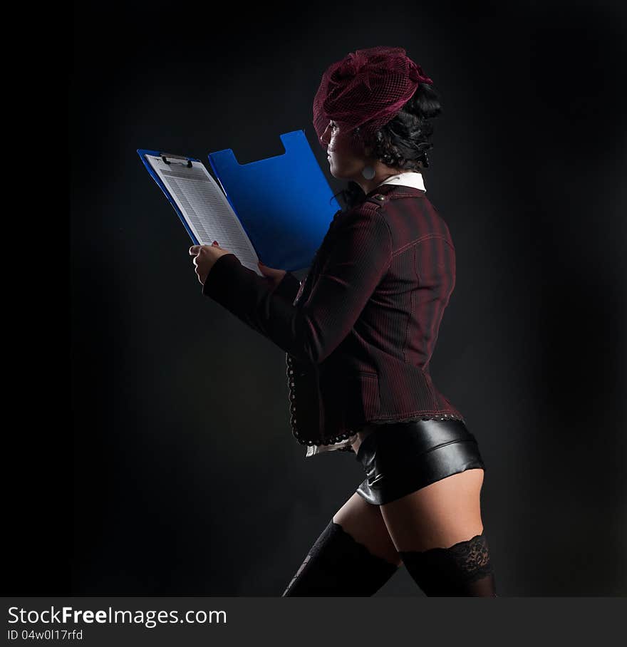 Portrait of woman in erotic clothes showing perfect body on a dark background in the studio. Portrait of woman in erotic clothes showing perfect body on a dark background in the studio