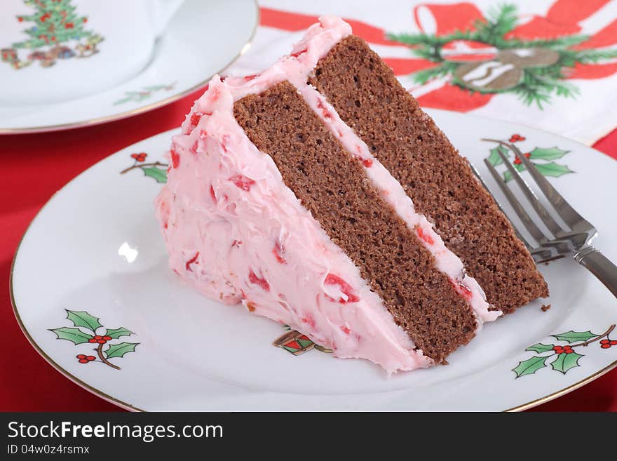 Slice of chocolate cake with cherry frosting on a Christmas plate. Slice of chocolate cake with cherry frosting on a Christmas plate