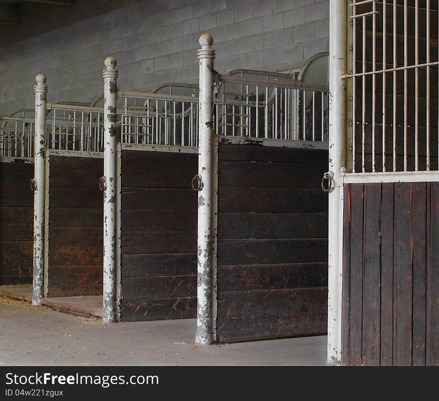 Close-up of empty horse stalls inside a building.