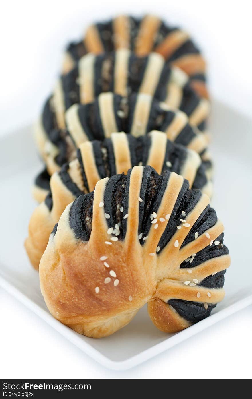 Sweet bread line with black sesame cream with sprinkle sesame put them in a white dish