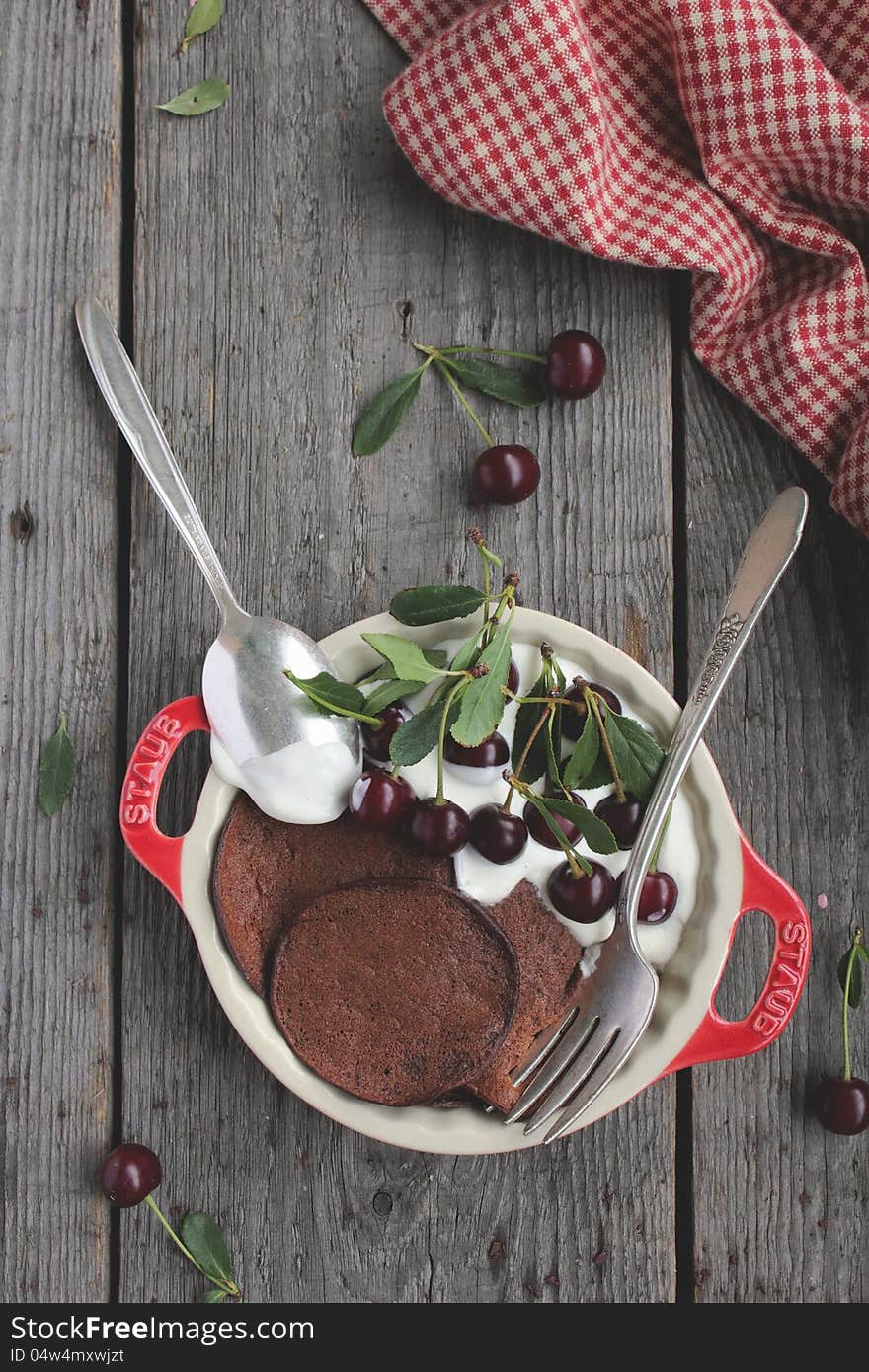 Chocolate pancakes with fresh cherries and vanilla sour cream in a bowl