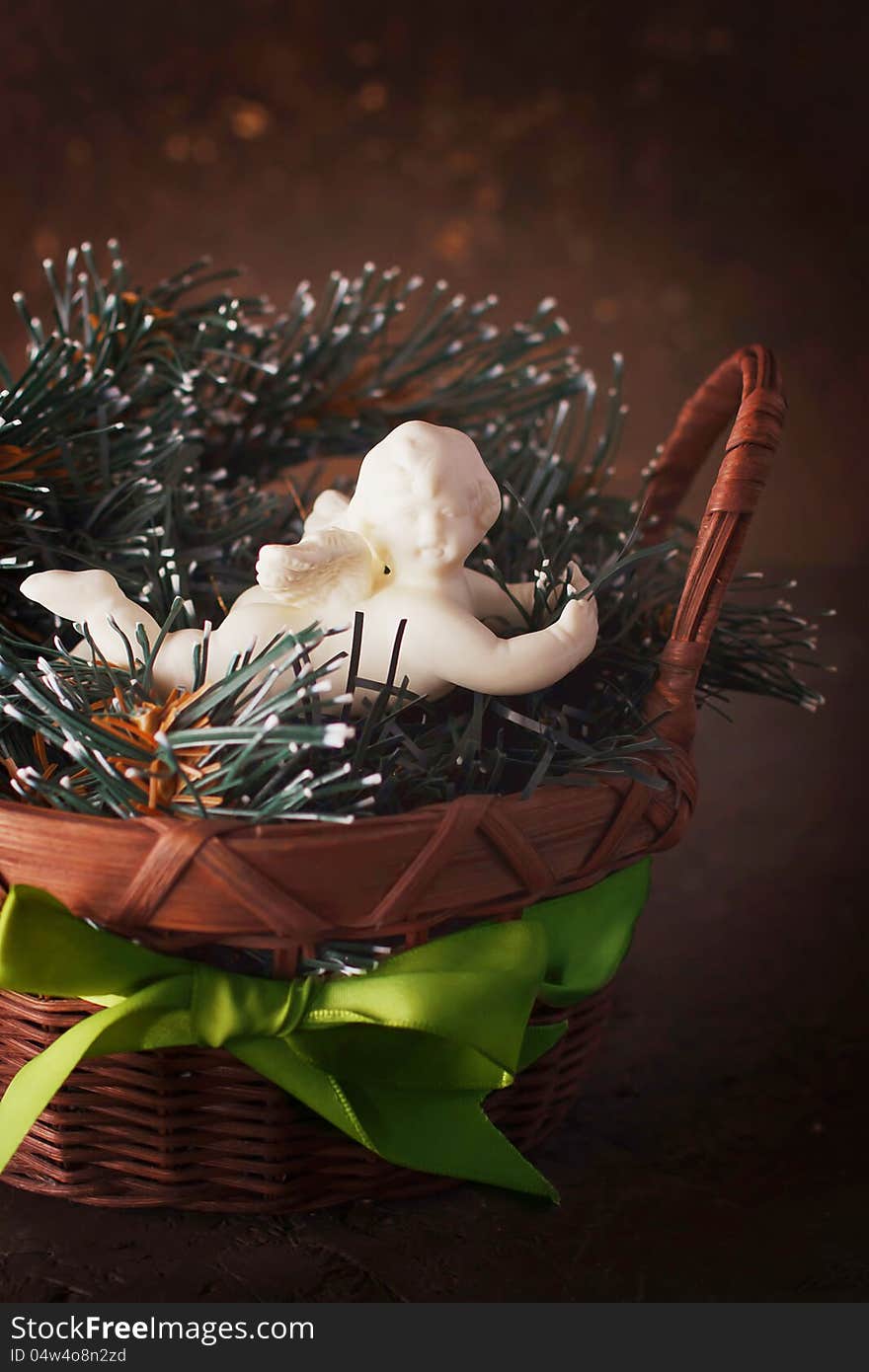 Christmas decoration with little cute angel in a wicker basket