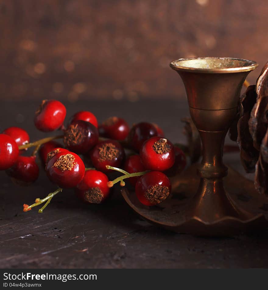 Christmas decoration with a vintage brass candlestick and red berries. Christmas decoration with a vintage brass candlestick and red berries