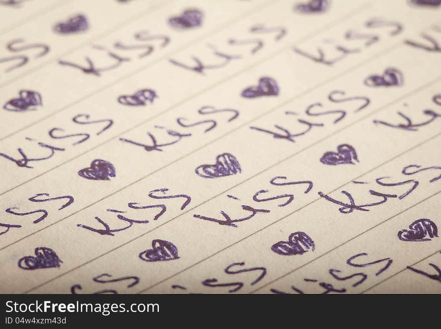 On a sheet of paper to handle a number of the written word kiss and heart icon. On a sheet of paper to handle a number of the written word kiss and heart icon