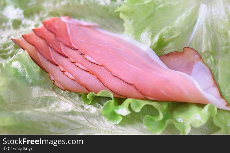 Smoked ham on lettuce leaf