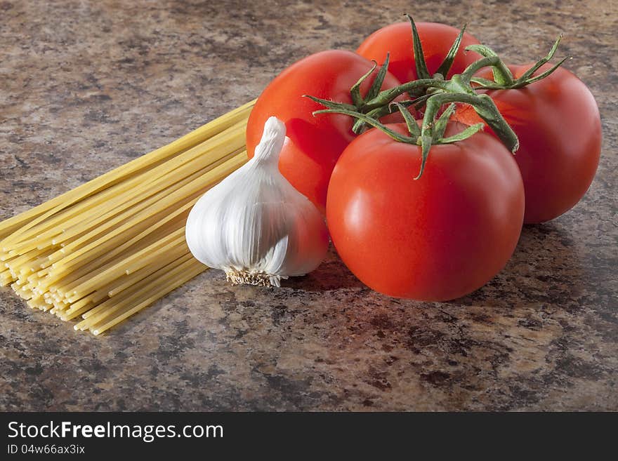 Tomato, pasta and garlic on kitchen table. Tomato, pasta and garlic on kitchen table.