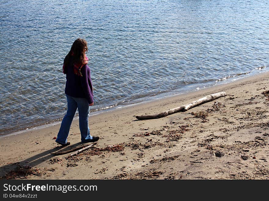 Brunette woman walking along empty beach