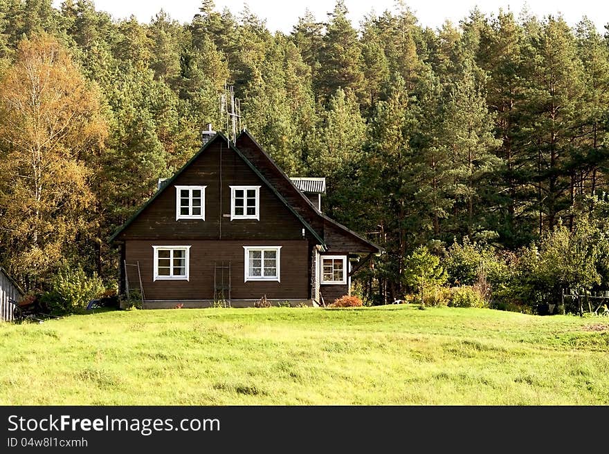 Rural landscape-old small wooden cottage next to the coniferous forest. Rural landscape-old small wooden cottage next to the coniferous forest