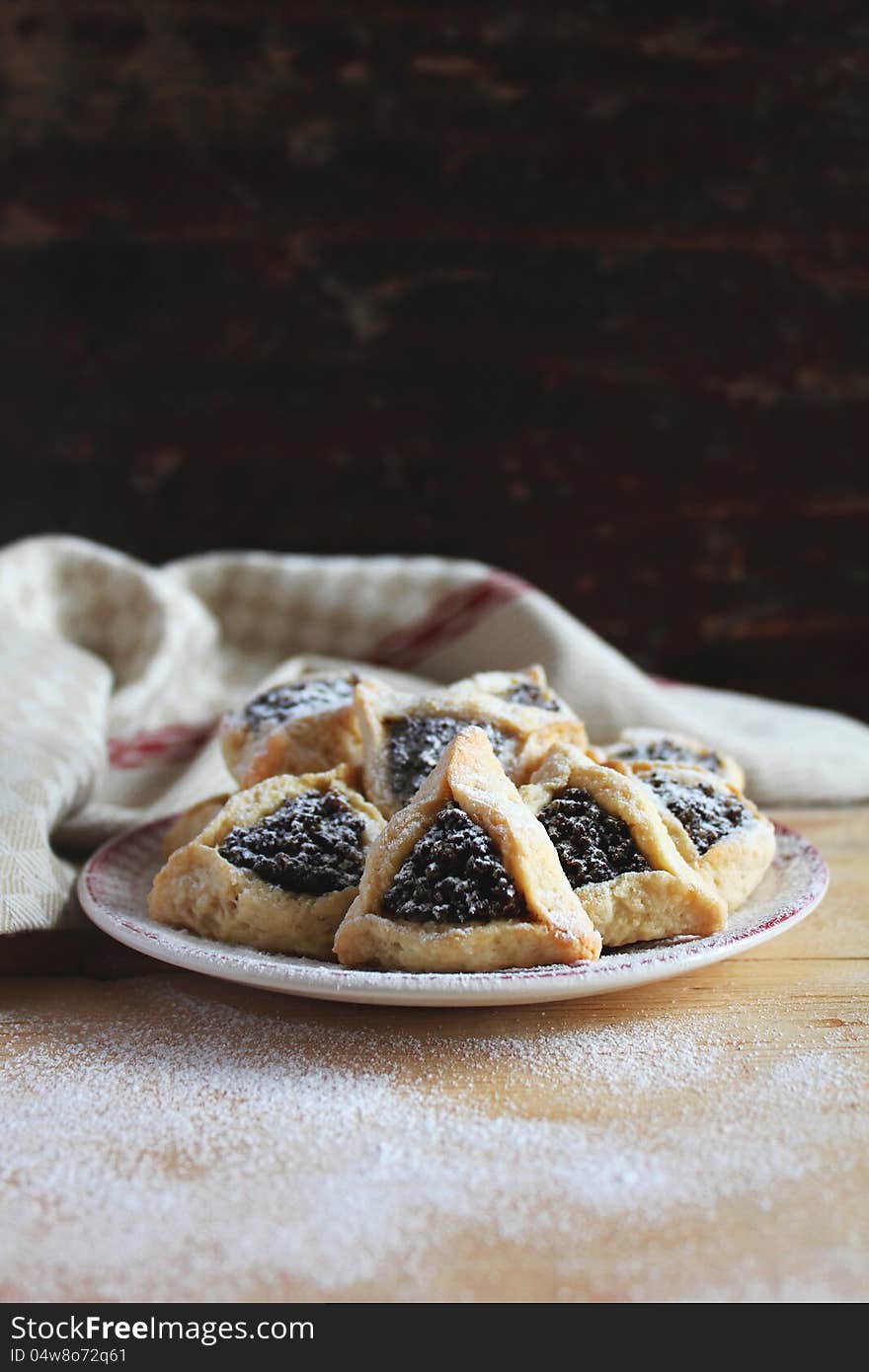 Cookies with date and poppy seed filling on a plate for a Jewish holiday Purim