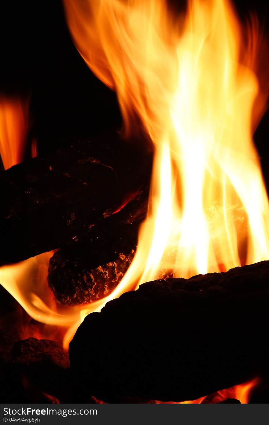 Logs burning brightly in a fire pit is great on a cool night, at home or camping. Logs burning brightly in a fire pit is great on a cool night, at home or camping.