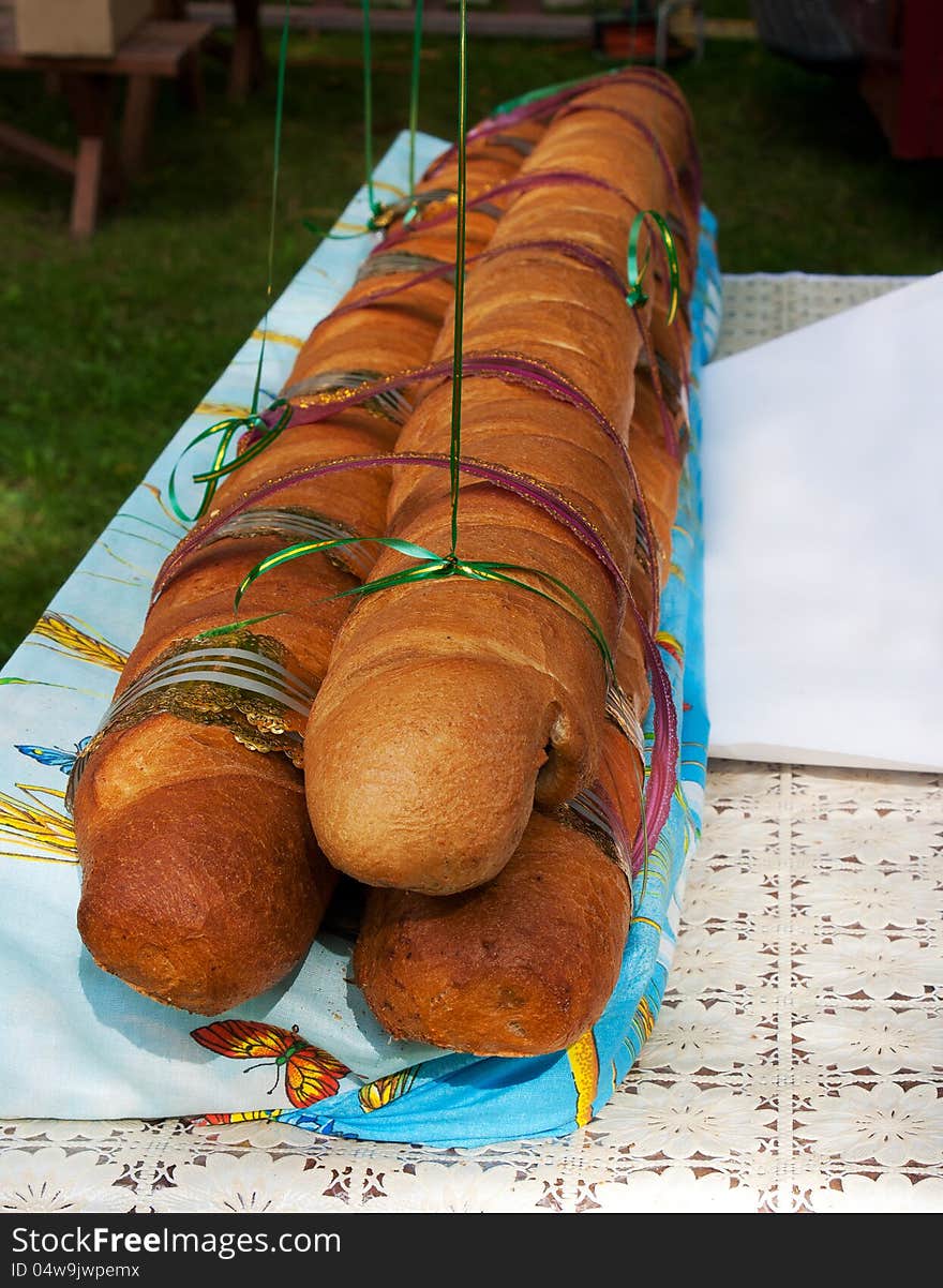 Big long bread on the table at the kirn outdoor. Big long bread on the table at the kirn outdoor