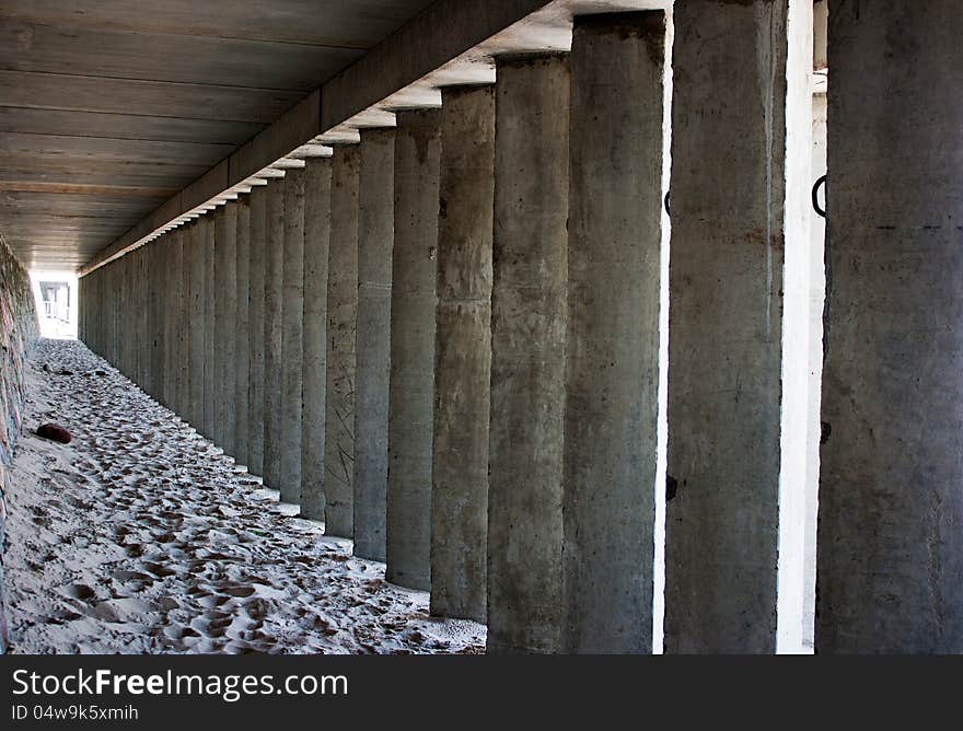 Empty corridor of concrete columns in the city beach