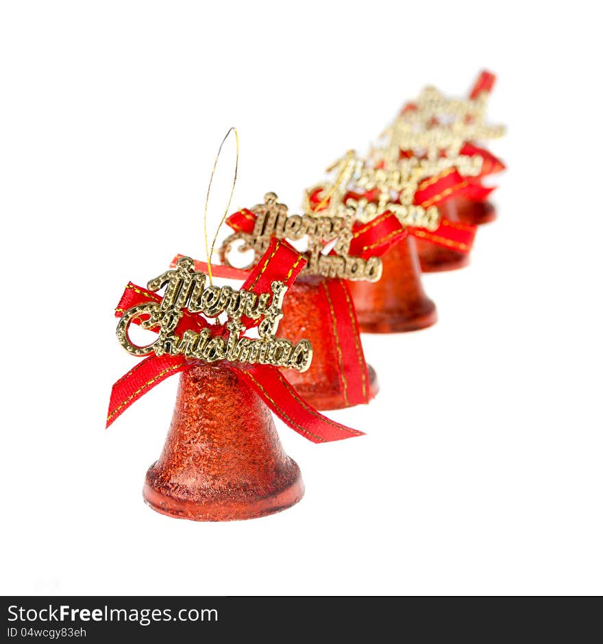 Red Christmas bells are standing in a row on white