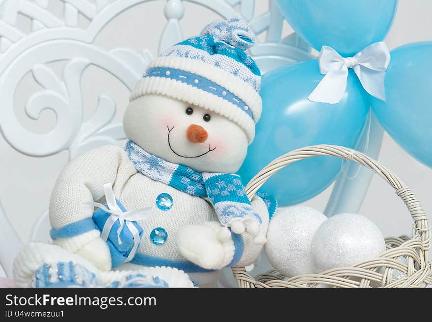 Snowman decoration with blue balloons and basket full of snowballs