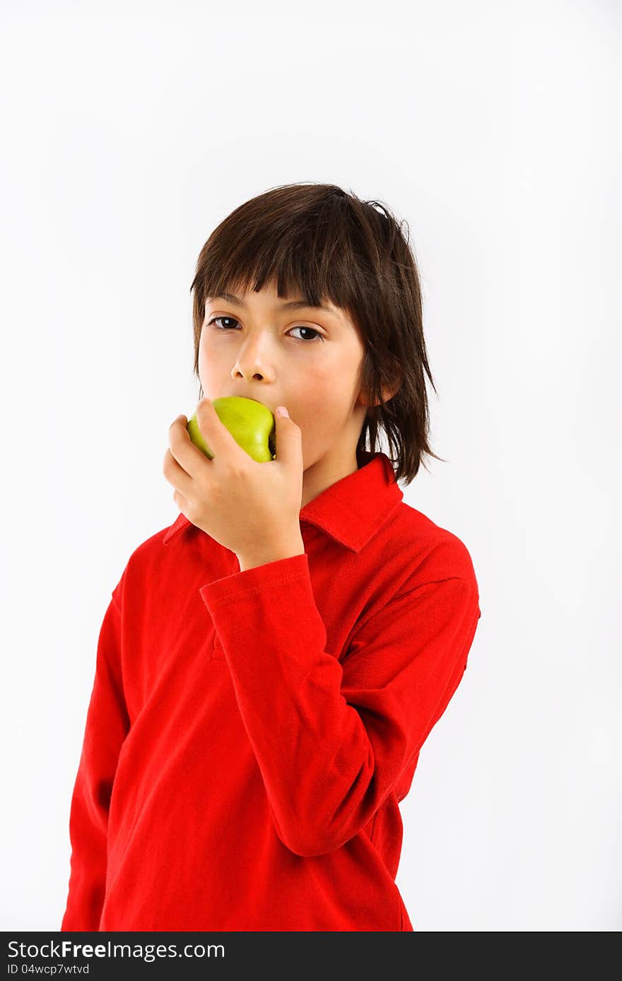 Boy eating a green apple isolated on white background