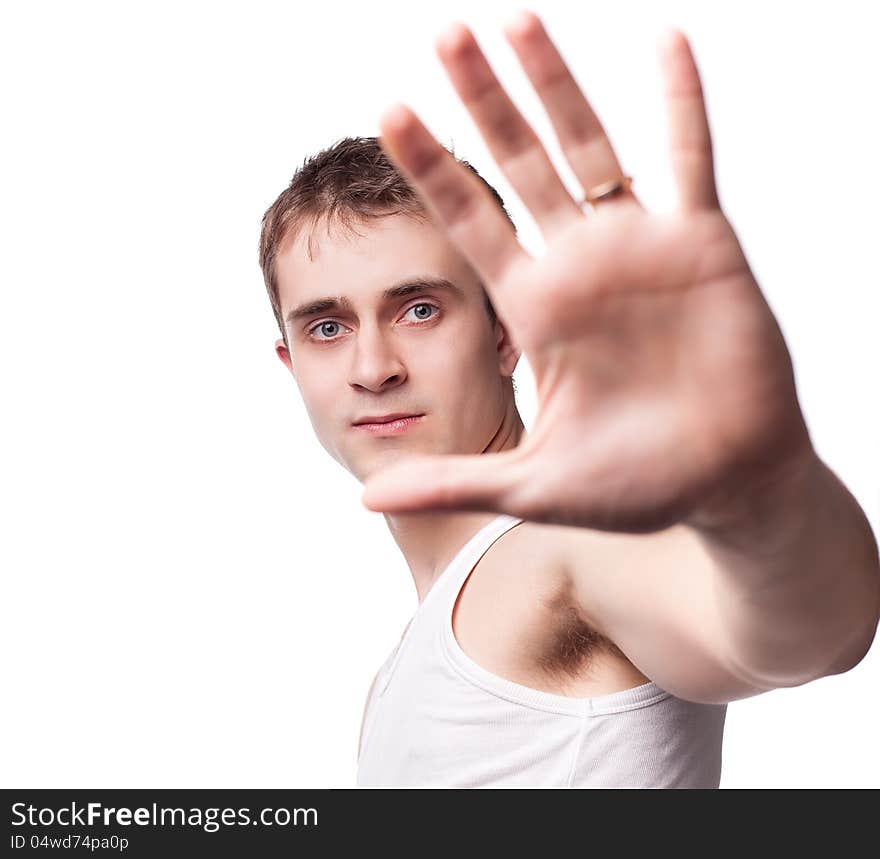 Portrait of a young man looking out from under raised hand on a white background