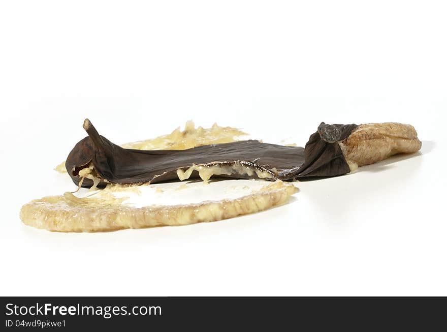 Closeup of smashed over ripe black banana on white. Closeup of smashed over ripe black banana on white