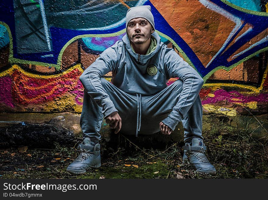 Fashion photo of young guy posing on bright wall