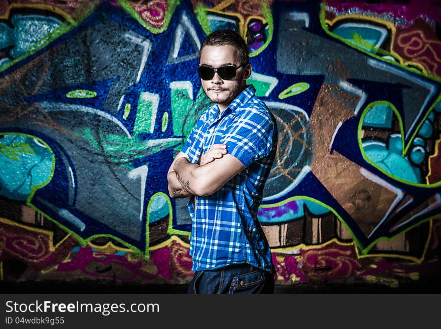 Fashion photo of young guy posing on bright wall