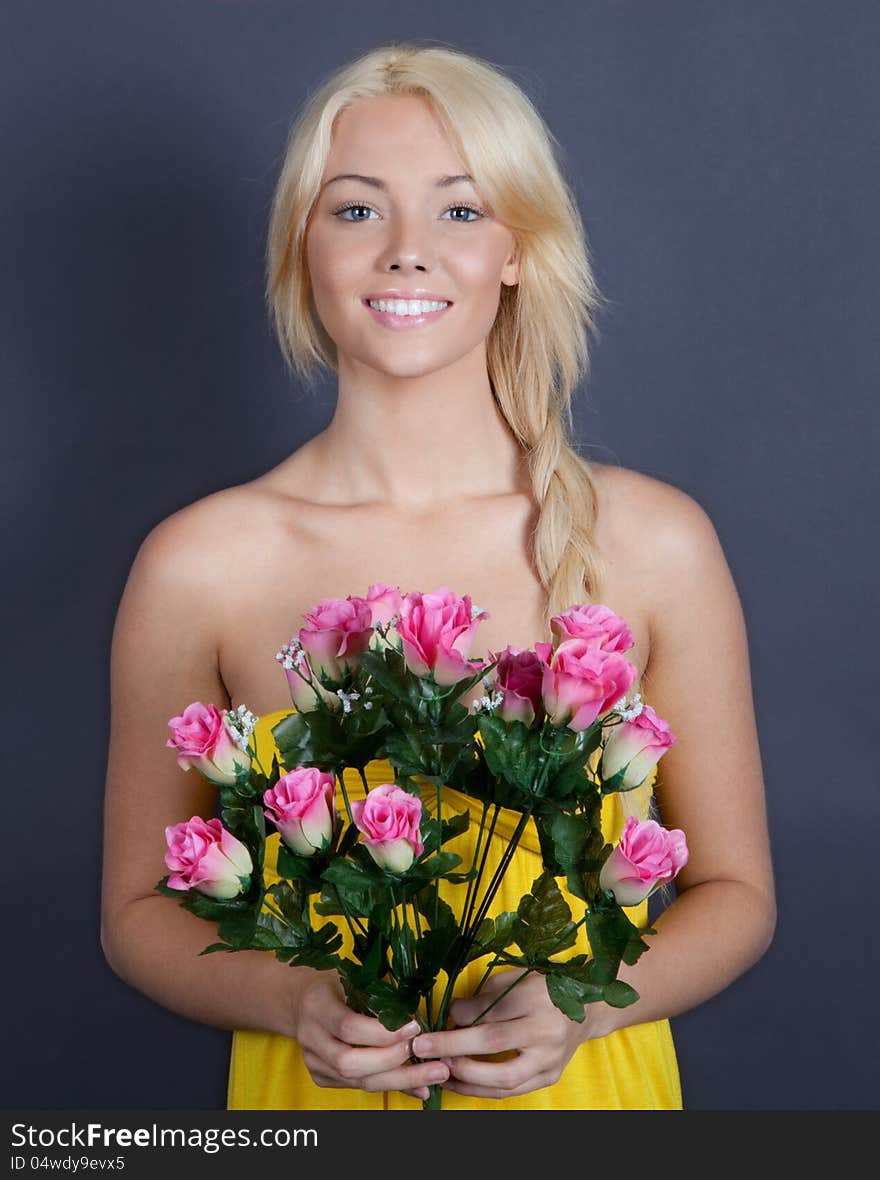 An portrait of a pretty young woman smiling and holding flowers. An portrait of a pretty young woman smiling and holding flowers