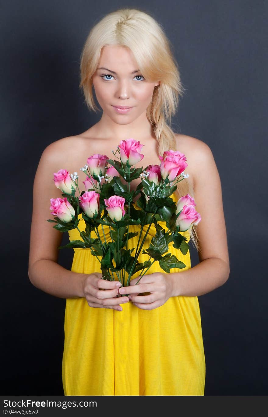 An image of a sweet young woman shyly holding a bouquet of pink flowers. An image of a sweet young woman shyly holding a bouquet of pink flowers