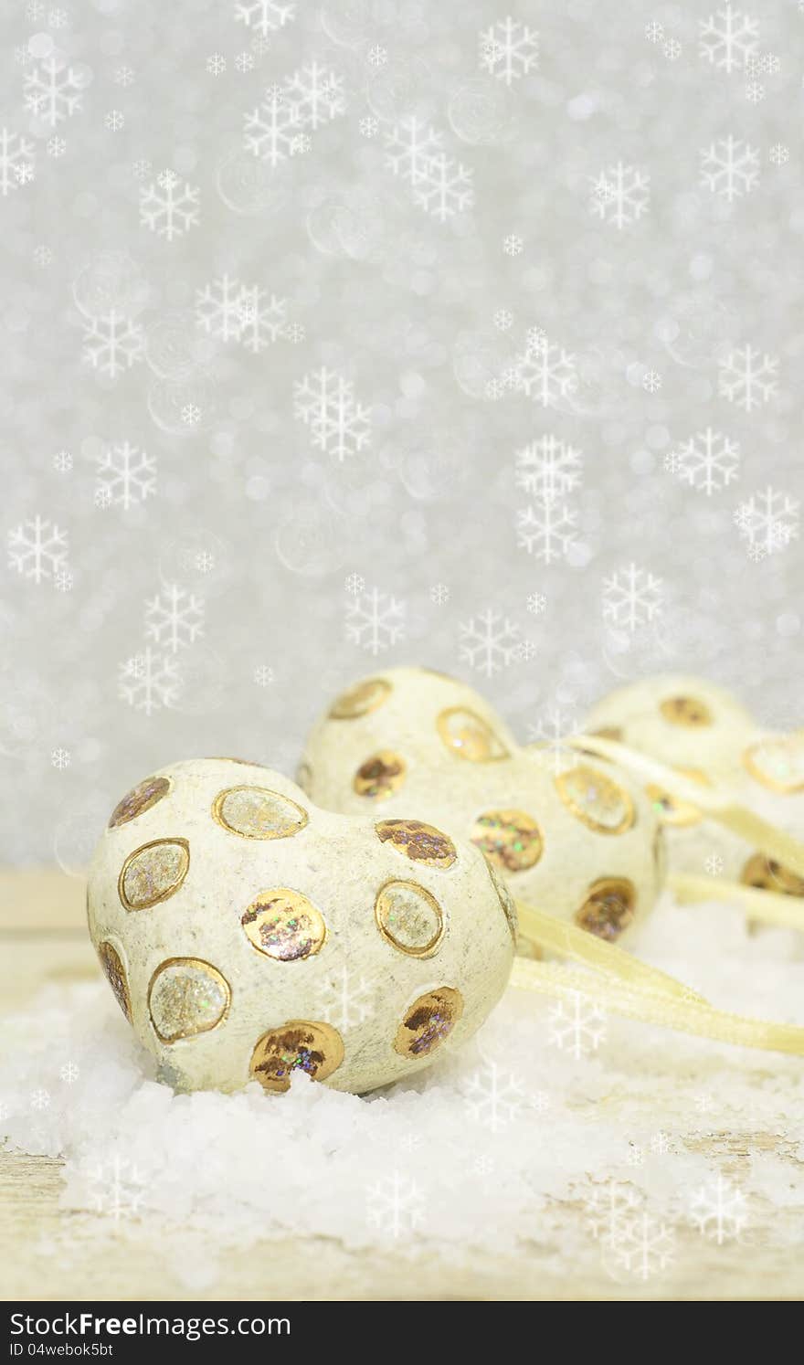 Old Christmas tree ornaments, heart shaped and lying on false snow. Old Christmas tree ornaments, heart shaped and lying on false snow