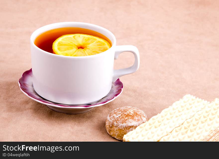 Tea with Lemon and sweet treats on the background of suede