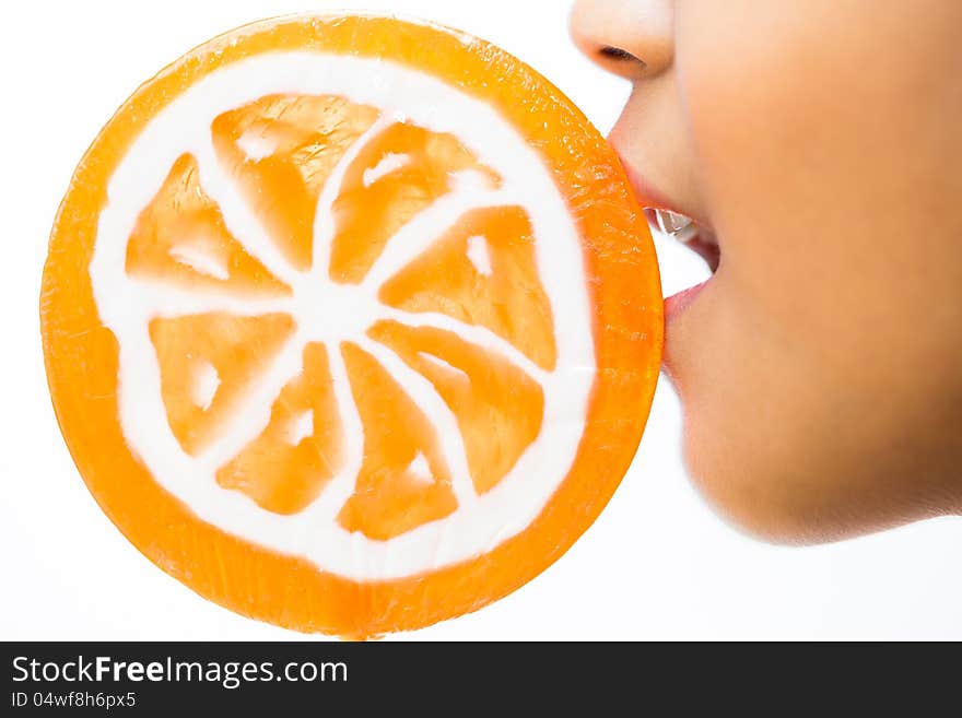 Closeup shot of little girl with orange lollipop ,Isolated over white