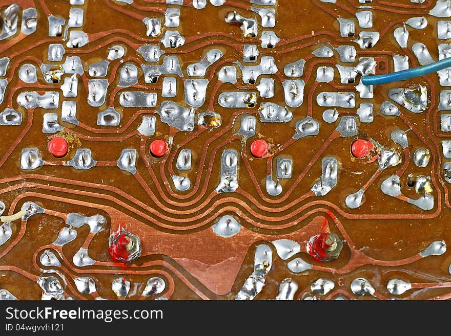 Vintage circuit board surface with tin soldering closeup technological background