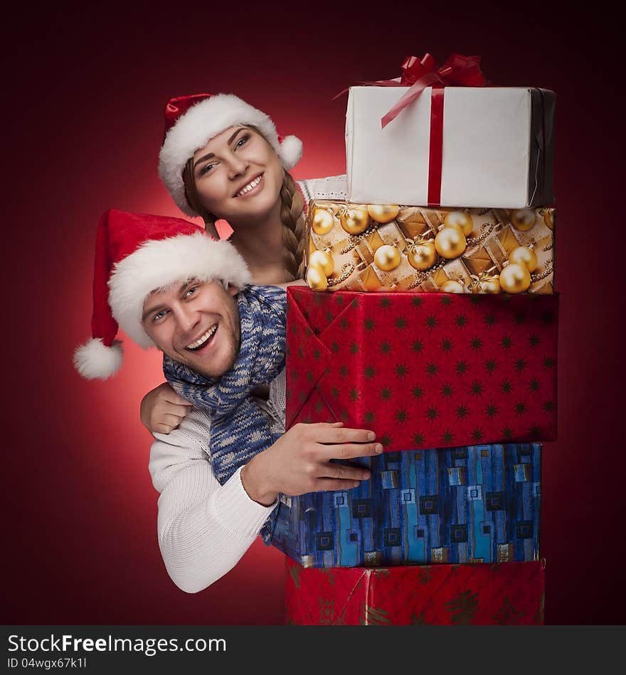 Young couple in Santa hats with presents isolated