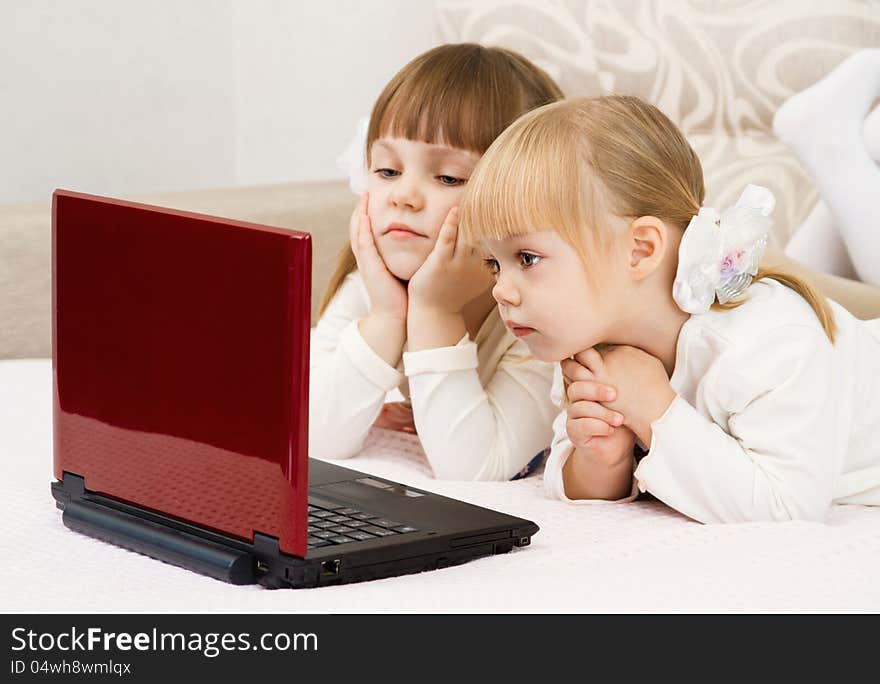 Two little girls are with a laptop and a credit card