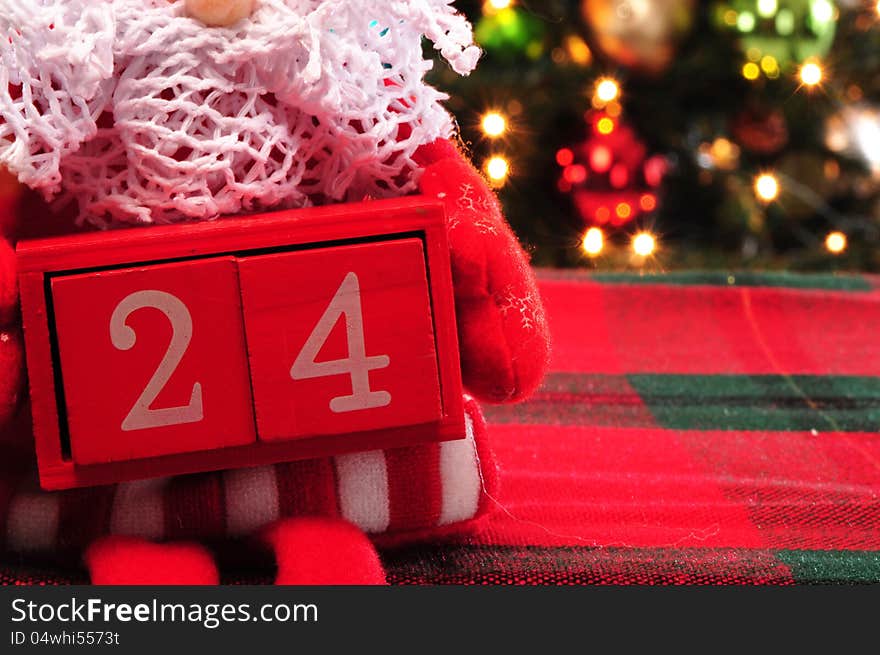 Red box with calendar date and christmas tree in the background . Red box with calendar date and christmas tree in the background .