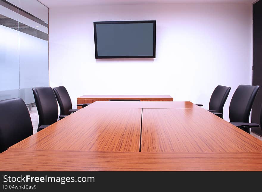 Furnished meeting room with display on wall. Furnished meeting room with display on wall.