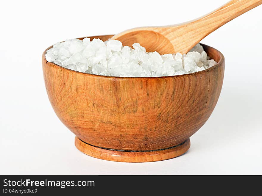 Sea salt in a wooden bowl on a white background