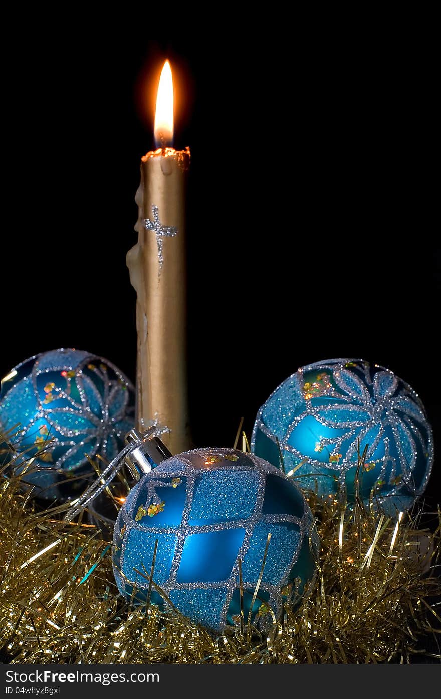 Burning candle and blue Christmas balls on a black background. Burning candle and blue Christmas balls on a black background