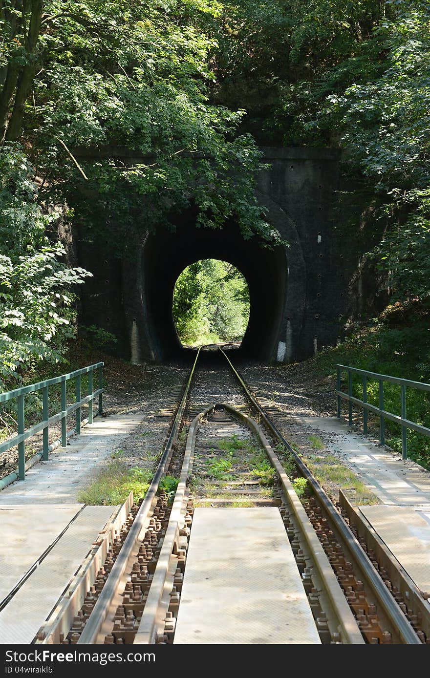 Train line in the Bakony (Hungary). Sunny light at the end of the tunnel.